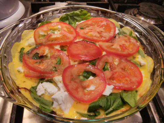 The egg mixture is poured on and topped with sliced tomatoes