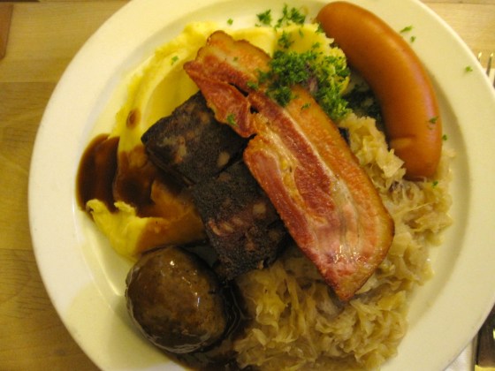 Koen's "Hausschlachtplatte - Variation aus Knoblauch- und gebackener Blutwurst, Leberkloß, Speckscheibe mit Sauerkraut und Zwiebelpüree" or "Butcher’s Platter - Combination of garlic sausage, baked black pudding, liver dumpling, grilled bacon with sauerkraut and mashed onions"