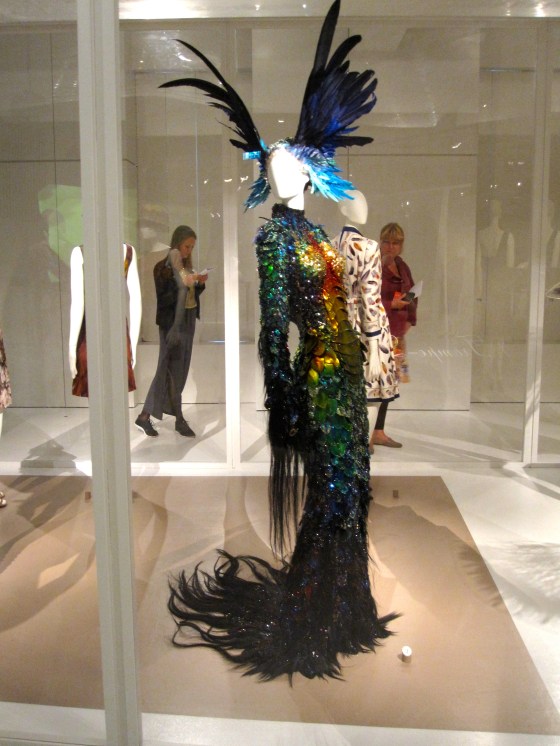 Theirry Mugler, Haute Couture Autumn-Winter 1997-1998; Dress as fantastical animal skin, bodice in thermally shaped man-made scales, embellished ith ostrich feathers, sequins, rhinestones, horse hair, and bead embroidery, head dress with dyed swan and goose feathers, sequins, and beads