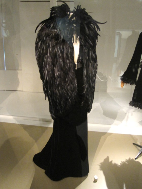 Yves Saint Laurent, Haute Couture Autumn-Winter 2000-2001; Evening ensemble of cape with rooster feathers and a dress in lacquered velvet