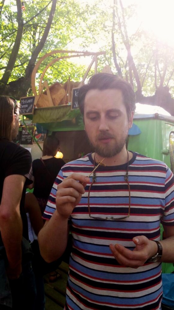 Koen eating a cricket on a stick from the Microbar