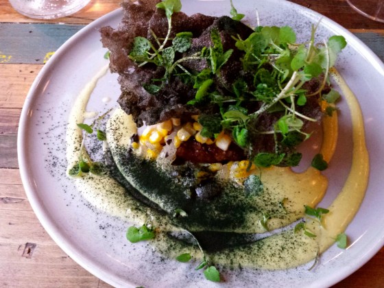 Beef tenderloin with horseradish, corn, trumpet mushrooms, onions, and a sauce with parsley and smoke marrow, topped with chips made from octopus ink